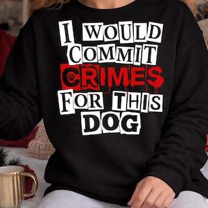May include: Black sweatshirt with the text "I WOULD COMMIT CRIMES FOR THIS DOG" in white and red lettering. The word "CRIMES" is in red with a paw print graphic. A cozy and comfortable apparel item for dog lovers.