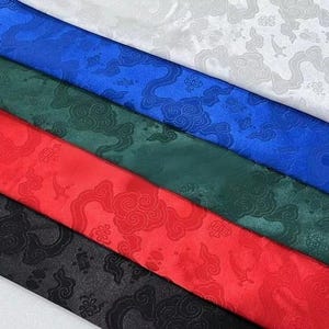 May include: Five strips of satin fabric arranged diagonally in white, blue, green, red, and black. Each strip features a tonal jacquard pattern of stylized clouds and traditional geometric motifs woven into the smooth, reflective material.