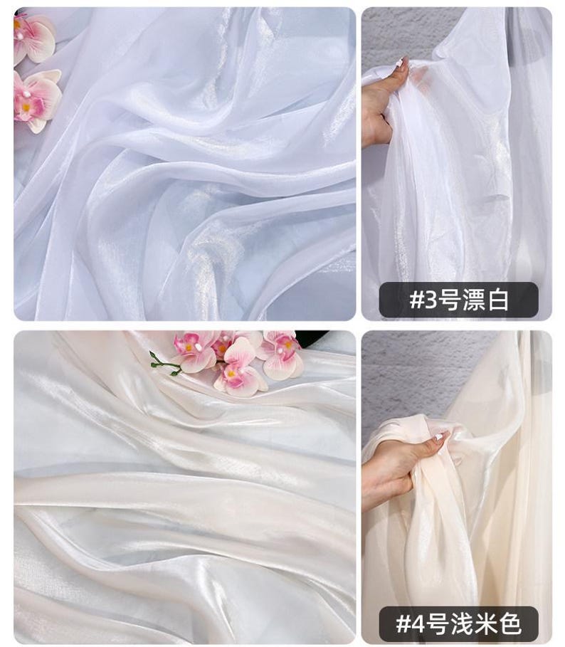 May include: White and off-white sheer fabric with a silky sheen. The fabric is draped and folded, creating soft waves. Pink orchids are placed on the fabric. The text "#3" and "#4" are visible.
