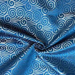 May include: Blue fabric with a silver swirl pattern. The fabric is textured and has a sheen.