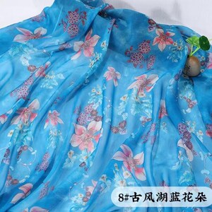 May include: A flowing, light blue fabric with a floral pattern in shades of pink and purple. The fabric is draped, creating soft folds and shadows. The text "8#" and Chinese characters are visible in the lower right corner.