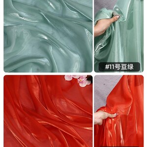 May include: Close-up shots of shimmering fabric in two colors: a soft, muted green and a vibrant red. The fabric appears to be lightweight and flowing, with a subtle sheen. The text "#11" and "#12" are visible.