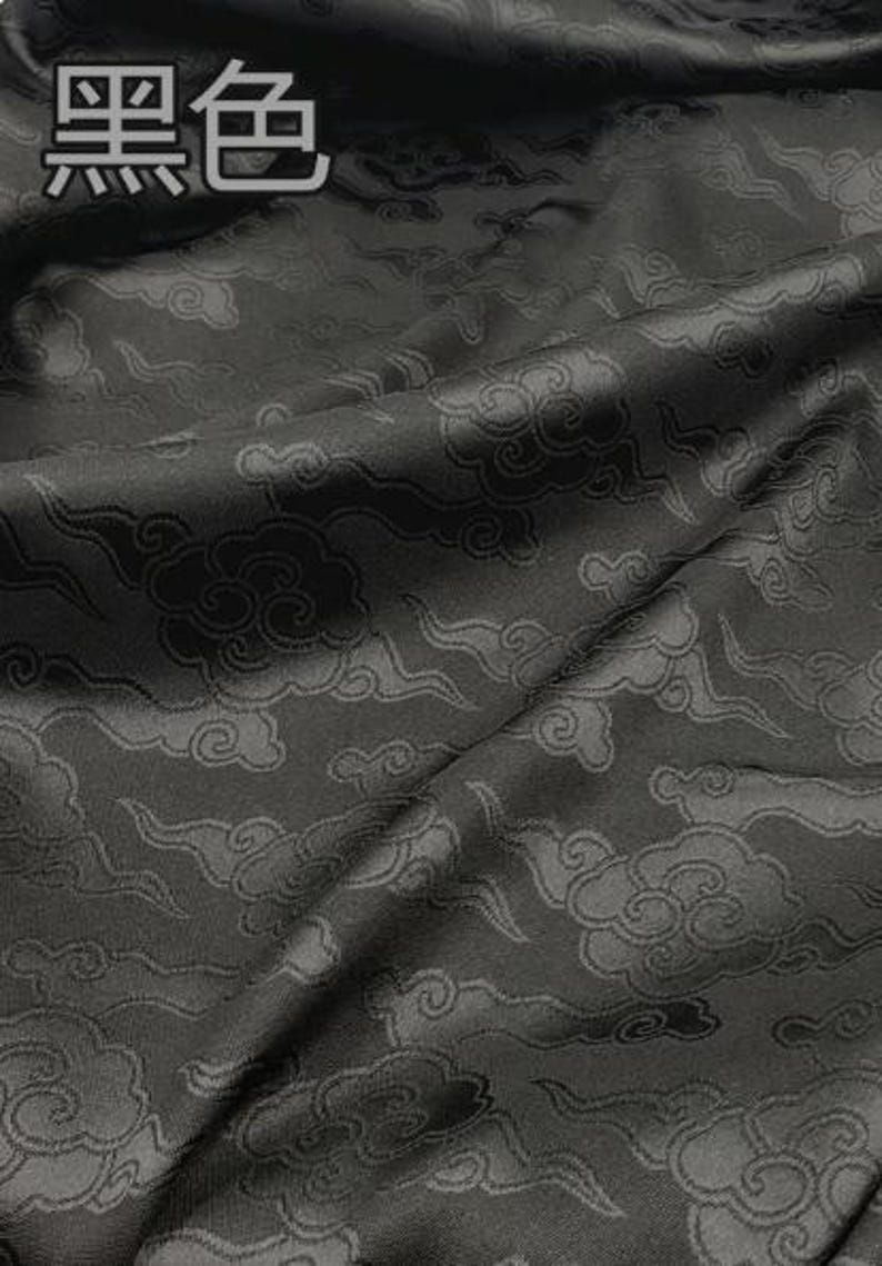 May include: A black fabric featuring a tonal jacquard pattern of stylized clouds. The fabric has a subtle sheen and folds naturally. The Chinese characters for black, 黑色, are printed in the upper left corner of the image in a light gray font.