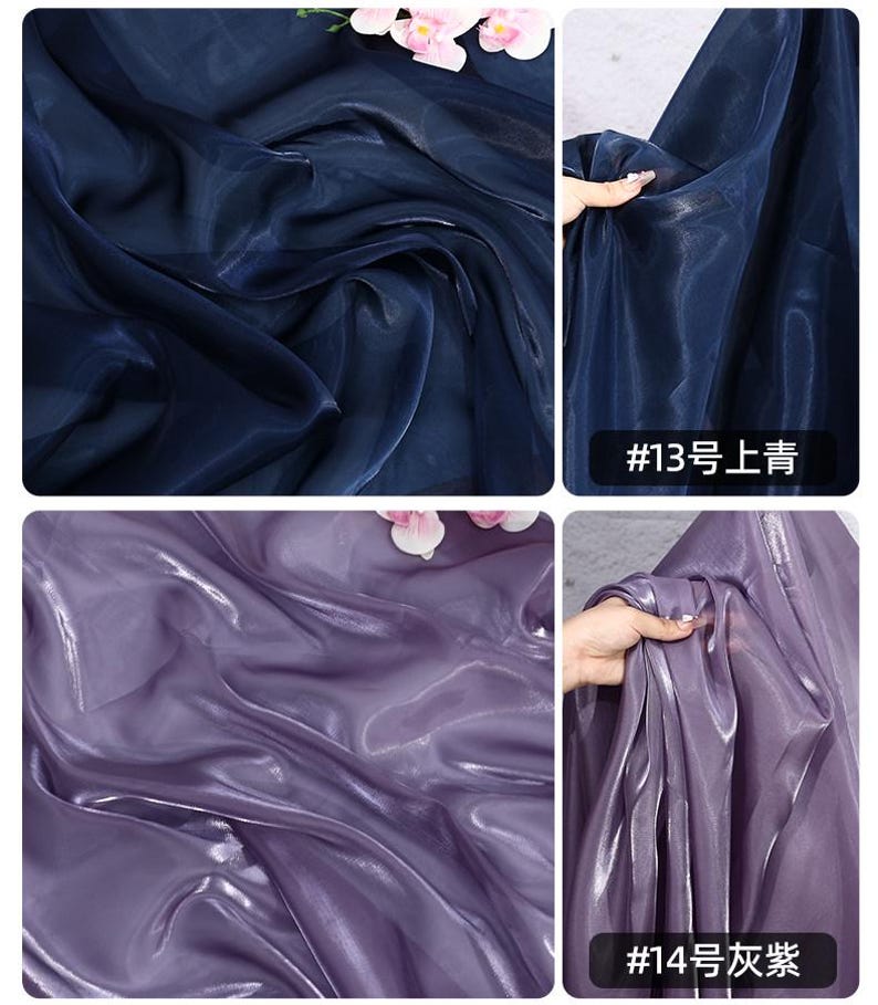 May include: Close-up of shimmering fabric in two colors: deep navy blue and a soft lavender-purple. The fabric has a flowing, translucent quality, with light reflecting off its surface. The image includes text in the bottom right corner.