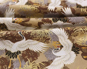 May include: Close-up of fabric with a repeating pattern of white cranes with outstretched wings, set against a backdrop of brown and gold floral elements. The fabric has a textured appearance, with visible folds and creases.