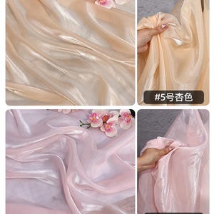 May include: Close-up of two sections of sheer fabric in peach and light pink. The peach fabric has the text "#5" and Chinese characters. The pink fabric has the text "#6" and Chinese characters. Artificial flowers are placed on top of the fabric.