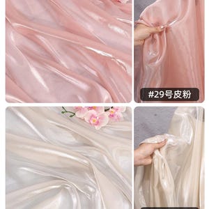 May include: Close-up of two types of sheer fabric. One is a light pink with the text "#29". The other is a cream color with the text "#30". Both fabrics have a shiny, iridescent quality and are draped to show their texture.