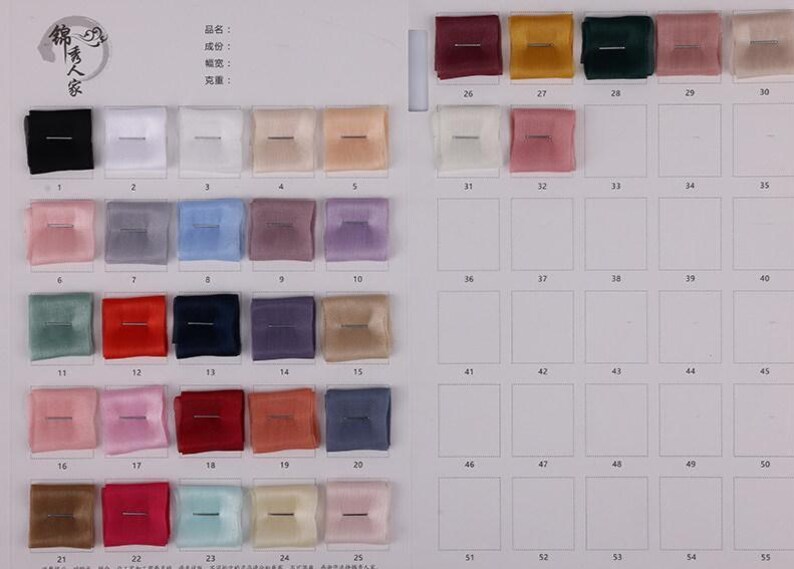 May include: A color swatch chart featuring a variety of fabric samples in a range of colors, including black, white, pink, blue, and brown. Each square sample is approximately 1 inch by 1 inch.