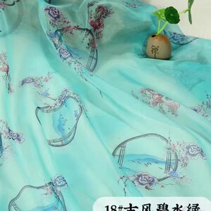 May include: A sheer, turquoise fabric with a floral and landscape print. The fabric has a watercolor effect with pink and purple flowers and a Chinese-style landscape design. The text "18#" and Chinese characters are visible.