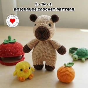 May include: A collection of five crocheted amigurumi toys, including a bear, a strawberry, a chick, an orange, and a turtle. The bear is tan with brown accents. The strawberry is red with a green top. The chick is yellow with orange feet.