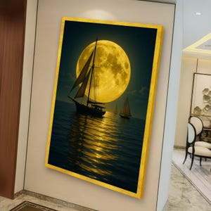 May include: A framed canvas art print depicts sailboats on the ocean under a large, yellow full moon. The water reflects the moonlight, creating a shimmering effect. The frame is gold.