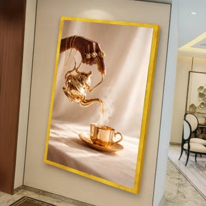 May include: A framed art print depicting a gold teapot pouring liquid into a matching teacup and saucer. The image has a warm, golden colour palette, with steam rising from the cup. The frame has a gold border.