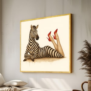 Könnte beinhalten: Ein gerahmtes Kunstwerk mit einem Zebra mit menschlichen Beinen, die rote High Heels tragen. Das Zebra liegt, mit gestreiftem Körper und Kopf im Profil. Das Kunstwerk hat einen goldenen Rahmen und ist vor einem neutralen Hintergrund platziert.
