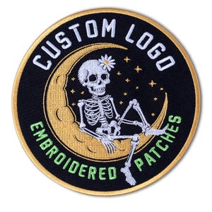 May include: Embroidered patch with a black background and a gold border. The patch features a skeleton lounging on a gold crescent moon, with a daisy in its head. The words "CUSTOM LOGO" and "EMBROIDERED PATCHES" are in white and green.
