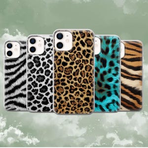 May include: Five phone cases with animal print designs. The cases feature zebra stripes, leopard spots, and tiger stripes in various colours, including black, white, brown, and teal. The cases are made of a clear material.