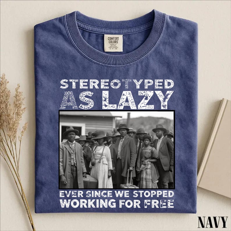 Puede incluir: Una camiseta azul marino de cuello redondo con una fotograf&iacute;a hist&oacute;rica en blanco y negro de un grupo de personas. El texto STEREOTYPED AS LAZY est&aacute; impreso sobre la imagen y EVER SINCE WE STOPPED WORKING FOR FREE debajo de la imagen.