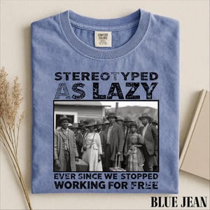 Puede incluir: Una camiseta de color azul vaquero con una fotograf&iacute;a hist&oacute;rica en blanco y negro de un grupo de personas con ropa formal. El texto sobre la imagen dice STEREOTYPED AS LAZY y el texto debajo dice EVER SINCE WE STOPPED WORKING FOR FREE.