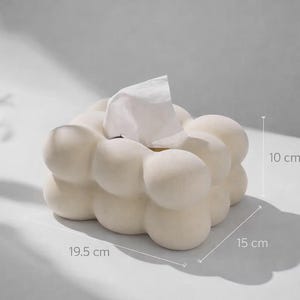 Puede incluir: Caja de pa&ntilde;uelos de color blanco roto con un dise&ntilde;o de burbujas &uacute;nico. La caja mide 19,5 cm de largo, 15 cm de ancho y 10 cm de alto. Se ven pa&ntilde;uelos blancos en la parte superior. La caja de pa&ntilde;uelos es de material s&oacute;lido.