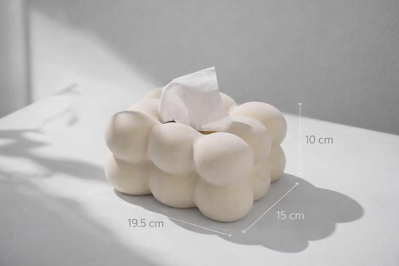Puede incluir: Caja de pa&ntilde;uelos de color blanco roto con un dise&ntilde;o de burbujas &uacute;nico. La caja mide 19,5 cm de largo, 15 cm de ancho y 10 cm de alto. Se ven pa&ntilde;uelos blancos en la parte superior. La caja de pa&ntilde;uelos es de material s&oacute;lido.