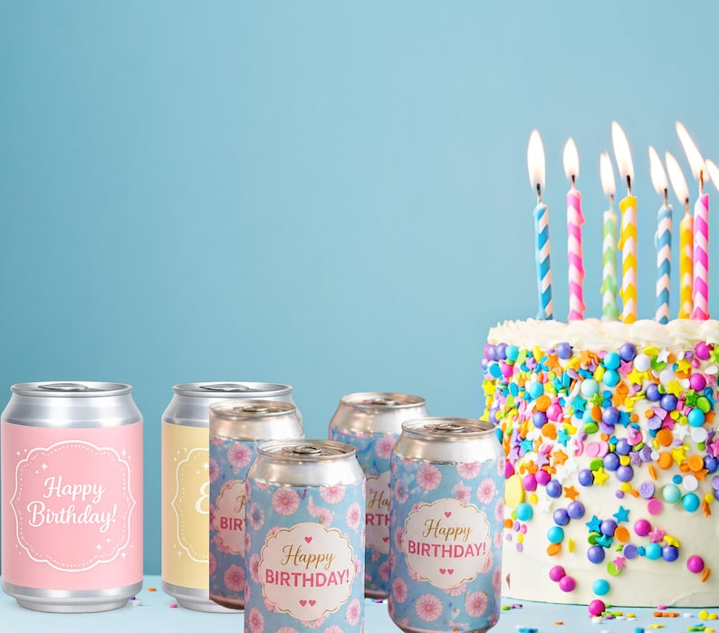 May include: A birthday celebration scene featuring several aluminum cans with "Happy Birthday!" labels, alongside a decorated cake with lit candles. The cans have floral and solid color designs.