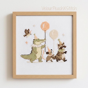 Könnte beinhalten: Kreuzstich-Kunstwerk in einem Holzrahmen. Das Bild zeigt eine Partyszene mit einem Alligator, einer Maus und einem Waschbären, die alle Partyhüte tragen. Der Alligator hält einen Ballon. Der Text "VelourPeachXStitch" befindet sich oben rechts.