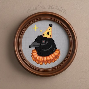 May include: Cross-stitch artwork of a black crow wearing a yellow party hat and orange ruffled collar, set in a round brown frame. A yellow star is next to the crow. The text "VelourPeachXStitch" is above the frame.