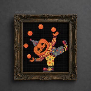 May include: A cross-stitch embroidery featuring a pumpkin-headed clown juggling four orange balls, set against a black background. The clown wears a blue hat, a yellow and red ruffled collar, and polka-dot pants. It is encased in an ornate bronze frame.