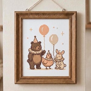 Könnte beinhalten: Ein gerahmtes Kreuzstichbild mit einem Bären, einem Huhn und einem Kaninchen, die jeweils eine Partyhut und eine Halskrause tragen. Der Bär hält einen pfirsichfarbenen Ballon, und das Kaninchen hält einen beigen Ballon. Der Text "VelourPeachXStitch" steht oben. Der Rahmen ist braun.