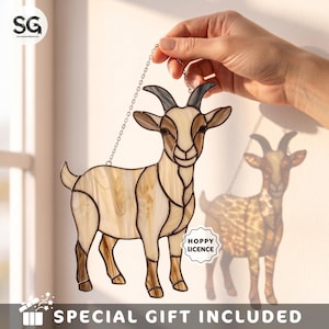 May include: A stained glass goat suncatcher featuring cream and brown swirled glass panels with dark gray horns. The goat is suspended by a silver metal chain and includes a small white tag with the text HOPPY LICENCE attached to the side.