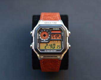 Casio AE-1200-horloge met aangepaste bruine leren band en zonsondergangoranje/geel model