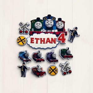 Könnte beinhalten: Eine Sammlung farbenfroher Dekorationen zum Thema Eisenbahn, darunter lächelnde Zuggesichter, der Name "Ethan", die Zahl "4" sowie verschiedene Zug- und Bahnübergangsschilder. Für eine Geburtstagsfeier.