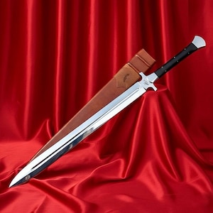 May include: A large, silver sword with a black handle and a brown leather sheath. The blade is highly polished and reflects the surrounding red fabric. The sword has a crossguard and a pointed tip. The sheath has a decorative design.