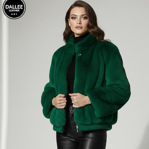 May include: A striking emerald green faux fur jacket featuring a high collar and a single button fastening. The jacket has long sleeves and a zip closure. The Dallee Leather logo is visible.
