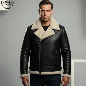 Könnte beinhalten: Schwarze Lederjacke mit cremefarbenem Lammfellkragen und -futter. Die Jacke hat einen Reißverschluss, zwei Vordertaschen und Lammfellbündchen. Das Dallee Leather-Logo befindet sich oben links.