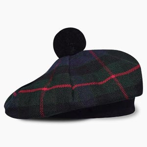 May include: A Scottish Tam o' Shanter hat with a tartan design. The hat has a black base and a crown with a green, navy, and red plaid pattern. A black pom-pom is on top. This hat is a traditional style.