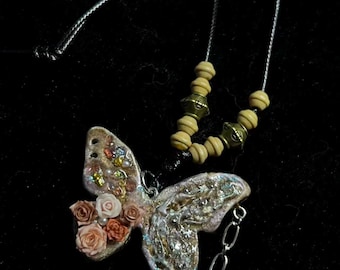 手作りの粘土製バタフライネックレス。花と輝きのディテールが施された職人の手によるユニークなジュエリー。