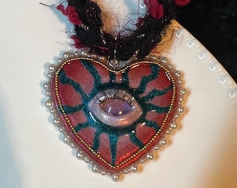 ふわふわのコードが付いた手作りの粘土製ハートアイネックレス。ギフトに最適な、気まぐれな職人のジュエリー。