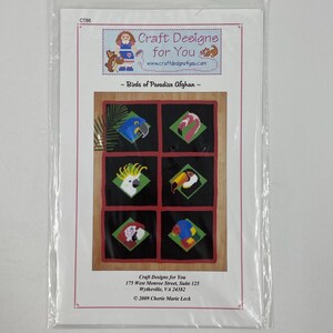 May include: A Birds of Paradise Afghan cross stitch pattern booklet by Craft Designs for You. The cover features a grid of six diamond-shaped bird illustrations including a macaw, flamingo, cockatoo, toucan, and others on a black background.