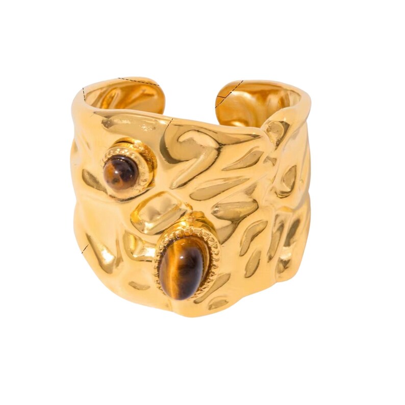 May include: A gold-coloured adjustable ring with a textured surface and two oval-shaped tiger's eye stones. The ring has a hammered metal design and a small round tiger's eye stone.