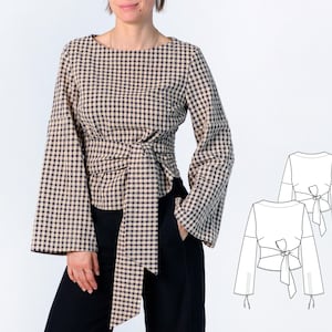 May include: A beige and navy blue gingham check long-sleeve top featuring wide bell sleeves and a wrap-style waist with a large fabric tie. The garment is shown alongside a technical line drawing illustration detailing the front and back design.
