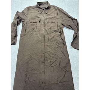 May include: A long-sleeved, button-down shirt dress in a solid brown color. The dress features a collared neckline, two chest pockets, and button closures down the front. The sleeves have buttoned cuffs.