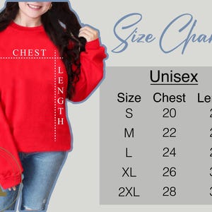 May include: A red unisex sweatshirt with a size chart. The chart lists chest and length measurements in inches for sizes S to 2XL. The sweatshirt has the word "CHEST" and "LENGTH" marked on it.