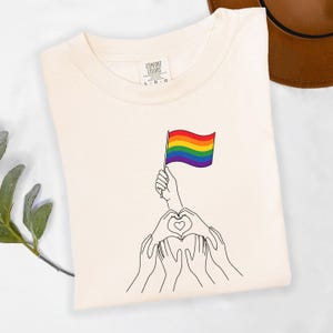 May include: A white ceramic mug with a black handle and the text "But First, Coffee" in a handwritten style. The mug is on a white surface. The mug is approximately 4 inches tall.