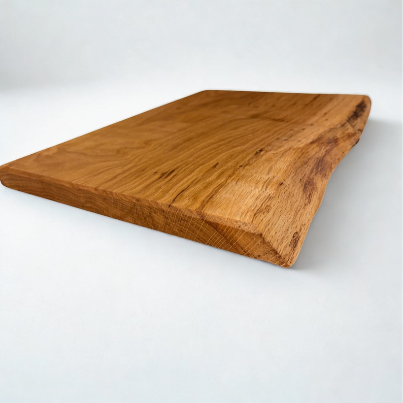May include: A rectangular wooden cutting board with a natural edge. The board is made of light brown wood with visible grain and a smooth surface. The board is approximately 18 inches long and 12 inches wide.