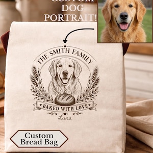 May include: A beige fabric bread bag featuring a dark brown printed graphic of a golden retriever dog, a loaf of bread, and wheat stalks. The text reads THE SMITH FAMILY, BAKED WITH LOVE, and Luna. A small inset shows a golden retriever dog photo.