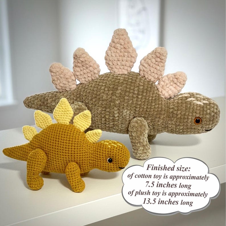 May include: Two crochet dinosaur toys. One is mustard yellow with yellow spines, the other is brown with tan spines. The cotton toy is approximately 7.5 inches long, and the plush toy is approximately 13.5 inches long.