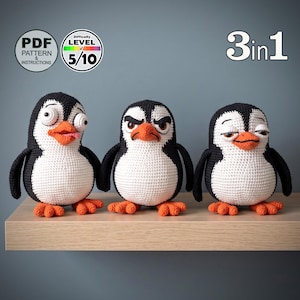 Peut inclure: Trois peluches pingouins au crochet avec des corps noirs et blancs, des becs et des pattes orange. Chaque pingouin a une expression faciale différente : un avec des yeux écarquillés, un avec un air fâché et un avec des yeux endormis. Texte 3in1.