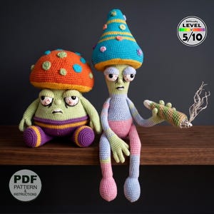 May include: Two crocheted mushroom-shaped figures. One has an orange cap with green and blue spots, the other a blue cone-shaped cap. One figure holds a crocheted cigarette with smoke. The text "Difficulty Level 5/10" is in the upper right corner. The text "PDF Pattern & Instructions" is in the lower left corner.