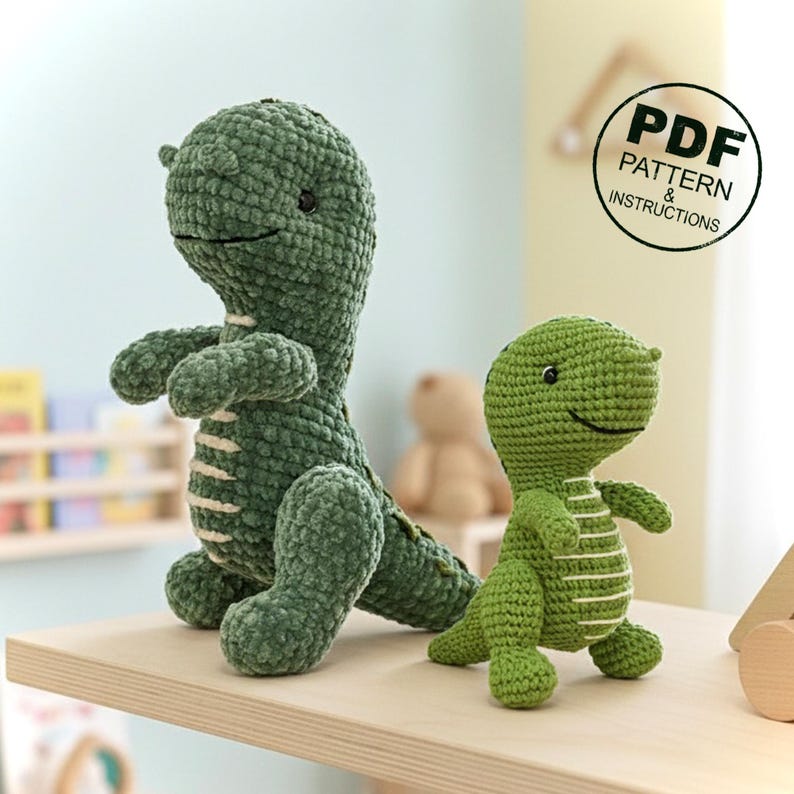 May include: Two green crochet dinosaur toys. The larger dinosaur is standing, and the smaller one is in front. Both have white stripes and smiling faces. The image includes a circular graphic that says "PDF PATTERN & INSTRUCTIONS."