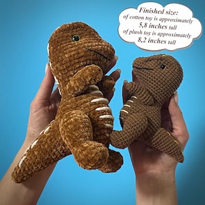 May include: Two brown crocheted dinosaur toys. The larger one is approximately 5.8 inches tall, and the smaller one is approximately 8.2 inches tall. The toys have white accents and are held against a blue background.